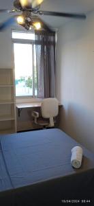 a bedroom with a bed and a chair and a window at Habitaciones y Suite. UPV, UV y Playa in Valencia
