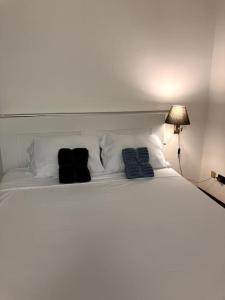 un letto bianco con due cuscini neri sopra di Casa Vigevanese CIR 018177-LNI-00019 a Vigevano