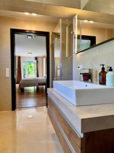 La salle de bains est pourvue d'un grand lavabo blanc. dans l'établissement Garten Apartment am Fluss, à Eriskirch