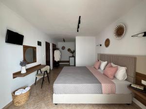 Dormitorio con cama, escritorio y TV en Pantheon, en Skiathos