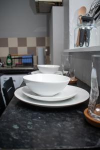two white bowls on a counter in a kitchen at Stylish 1 Bedroom Flat Newcastle in Old Walker