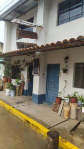 a building with a blue door and potted plants at Hospedaje Quillabamba in Santa Teresa +6 photos