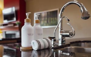 two bottles of detergent sitting next to a kitchen sink at Panoramic Mountain View Condo in Canmore