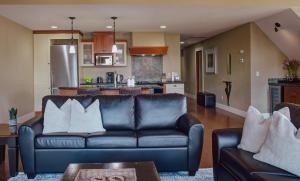 a living room with a couch and a kitchen at Panoramic Mountain View Condo in Canmore