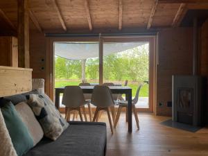 ein Esszimmer mit einem Tisch, Stühlen und einem Fenster in der Unterkunft Le Rucher Mirabelle in Coeuve
