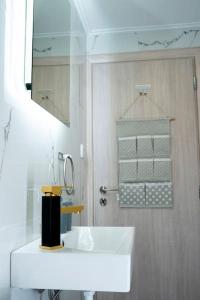y baño con lavabo blanco y espejo. en LoftLiving 2 by ΑΤΤΙΚΟ ΝΟΣΟΚΟΜΕΙΟ en Atenas