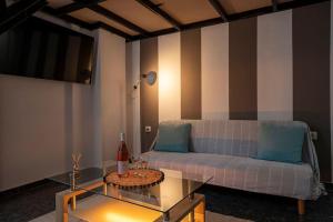 アテネにあるLoftLiving 2 by ΑΤΤΙΚΟ ΝΟΣΟΚΟΜΕΙΟのソファとガラスのテーブルのあるリビングルーム
