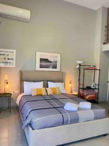1 dormitorio con 1 cama grande con almohadas amarillas en Cozy apartment near to the airport en Kouvarás