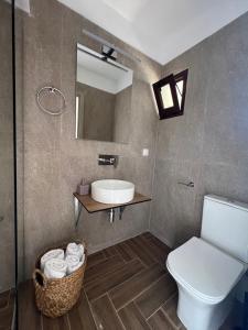 uma casa de banho com um lavatório, um WC e um espelho. em Pantheon em Skiathos Town