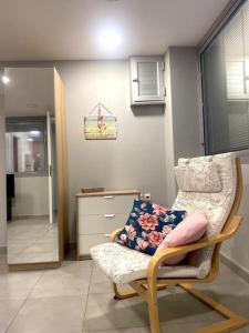 um quarto com uma cadeira e uma cómoda em Cozy apartment near to the airport em Kouvarás