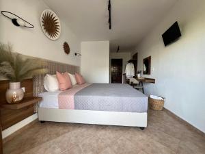 1 dormitorio con 1 cama con almohadas rosas en Pantheon, en Skiathos