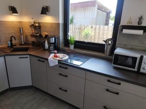 cocina con encimera, microondas y ventana en Ferienwohnung Treibgut en Saal