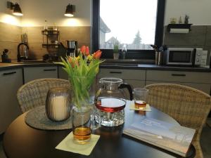 una mesa con una botella de vino y flores. en Ferienwohnung Treibgut en Saal