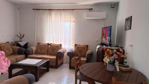 a living room with a couch and a table at Green Haven Cottage in Delvinë