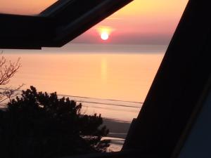 a sunset over the ocean from a house balcony at Appartement 45m2 - Proche Deauville - Vue Mer in Bénerville-sur-Mer +37 photos