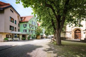 una calle en una ciudad con un árbol y edificios en Hotel-Restaurant Schwanen, en Metzingen