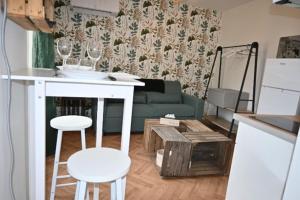 a living room with a green couch and wine glasses at Le Botanique Centre Clim WIFI in Châteauroux