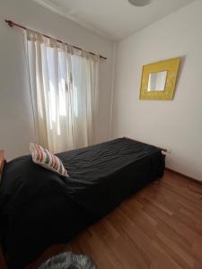 um quarto com uma cama preta e uma janela em Rosario centro em Rosário