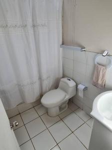 ein weißes Bad mit einem WC und einem Waschbecken in der Unterkunft Casa a orilla del lago in Pucón