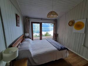 Schlafzimmer mit einem Bett und Meerblick in der Unterkunft Casa a orilla del lago in Pucón