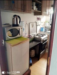 kuchnia z kuchenką mikrofalową na lodówce w obiekcie faraja homes w mieście Kakamega