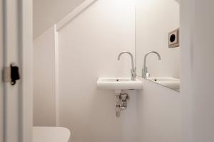 a white bathroom with a sink and a shower at Duplex de lujo junto al Bernabéu Real Madrid in Madrid