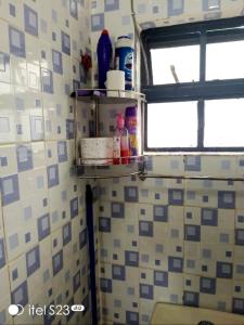 uma casa de banho com uma prateleira numa parede de azulejos em faraja homes em Kakamega