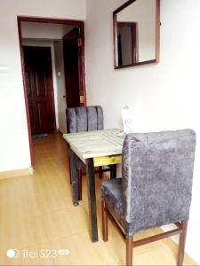 a dining room table with chairs and a mirror at faraja homes in Kakamega