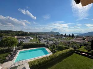 einen Pool im Garten mit Stadtblick in der Unterkunft Garda Moon Flats in Costermano sul Garda