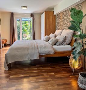 - une chambre avec un grand lit et un mur en briques dans l'établissement Garten Apartment am Fluss, à Eriskirch