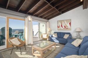 uma sala de estar com um sofá azul e uma mesa em Oceans 2 condo em Pine Knoll Shores