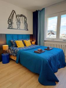 Un dormitorio con una cama azul con toallas. en Good Night in Szczecin en Szczecin