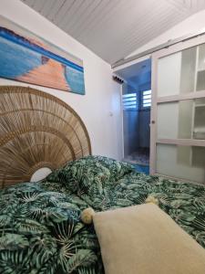 ein Schlafzimmer mit einem Bett und einem Wandgemälde in der Unterkunft Plézi Location F3 au bord de mer, Trois-Ilets in Les Trois-Îlets