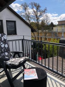 Un balcón con una silla y una mesa en un porche en Apartment Leuchtberg Flair Eschwege, en Eschwege