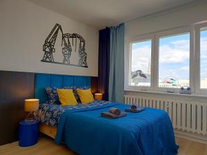 Un dormitorio con una cama azul con toallas. en Good Night in Szczecin en Szczecin
