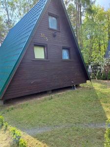 a house with a gambrel roof with the number on it at Domek Ostrowo in Ostrowo