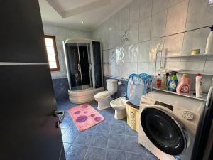 a bathroom with a washing machine and a toilet at Vila Mani in Durrës