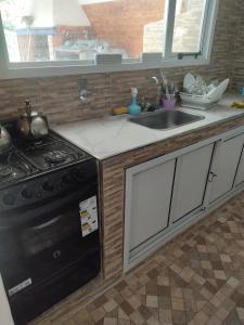 a kitchen with a stove and a sink at Salon para eventos o reunion empresarial in Plottier