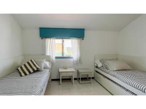 2 Betten in einem Zimmer mit Fenster in der Unterkunft Perbes in Miño