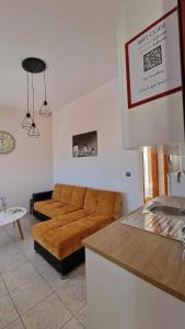 ein Wohnzimmer mit einer braunen Couch in einer Küche in der Unterkunft Kofinaki apartment 2 in Tycherón