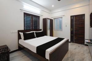 um quarto com uma cama grande e lençóis brancos e pretos em Hotel Stay inn Chennai Airport em Chennai