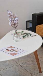 a white coffee table with a vase of flowers on it at Kofinaki apartment 2 in Tycherón