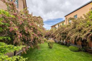una fila de árboles con flores rosas en un patio en Center Apartments Milano - Exclusive Park House Navigli, en Milán