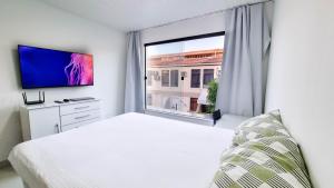 ein weißes Schlafzimmer mit einem großen Fenster und einem Bett in der Unterkunft A Poucos Passos da Praia Condomínio Arauá Ilha de Itaparica in Vera Cruz de Itaparica