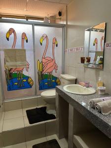 ein Bad mit rosa Flamingos an der Wand in der Unterkunft Elegante apartamento cerca del aeropuerto, Garzota in Guayaquil