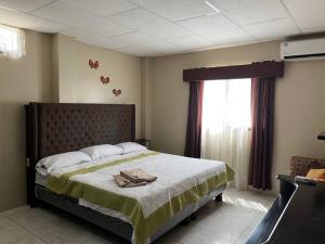 ein Schlafzimmer mit einem großen Bett und einem Fenster in der Unterkunft Elegante apartamento cerca del aeropuerto, Garzota in Guayaquil