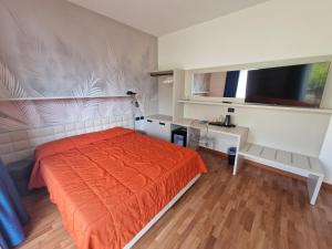 sypialnia z pomarańczowym łóżkiem i biurkiem w obiekcie Hotel Internazionale w mieście Malcesine
