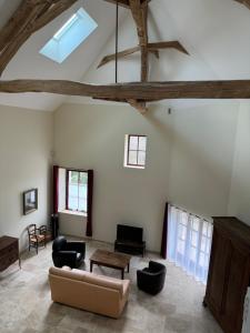 a living room with a vaulted ceiling with a couch and chairs at Gîte La Maison des Poètes de 1 à 6 personnes à Treigny Perreuse in Perreuse