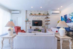 a living room with two white couches and a fireplace at Palacio Blanco Luxury Villa 1 in La Ventana