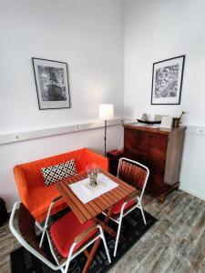 a dining room with an orange couch and a table at Olive Tree City Apartment in Zagreb